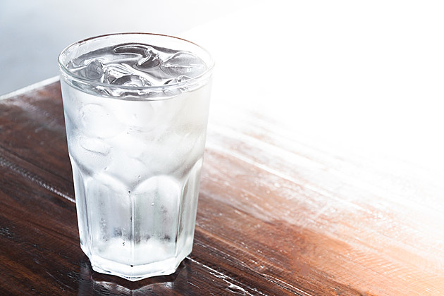 glass of water with ice on wooden table , clean water,drinking water